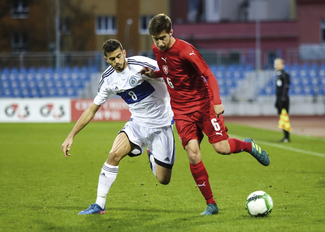 Michal Sáček (vpravo) se snaží uniknout Lorenzovi Lunadelovi ze San Marina v kvalifikačním zápase fotbalistů do 21 let