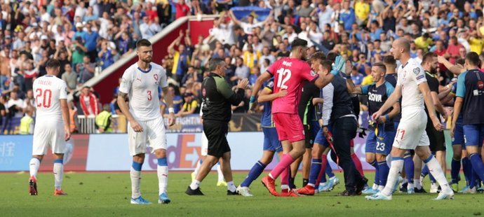 Zklamaní čeští fotbalisté po prohře v Kosovu, jehož hráči se v pozadí radují z výhry 2:1