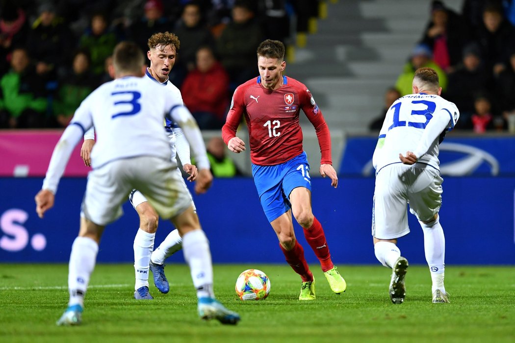 Lukáš Masopust se pokouší projít kolem bránících hráčů Kosova v zápase kvalifikace o postup na EURO 2020