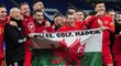 Gareth Bale oslavuje se spoluhráči z velšské reprezentace postup na EURO s vlajkou, která má znázorňovat jeho priority v pořadí Wales, golf, Madrid