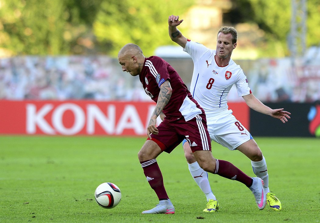 Český reprezentant David Limberský atakuje lotyšského fotbalistu Denisse Rakelse v utkání kvalifikace o postup na EURO 2016.