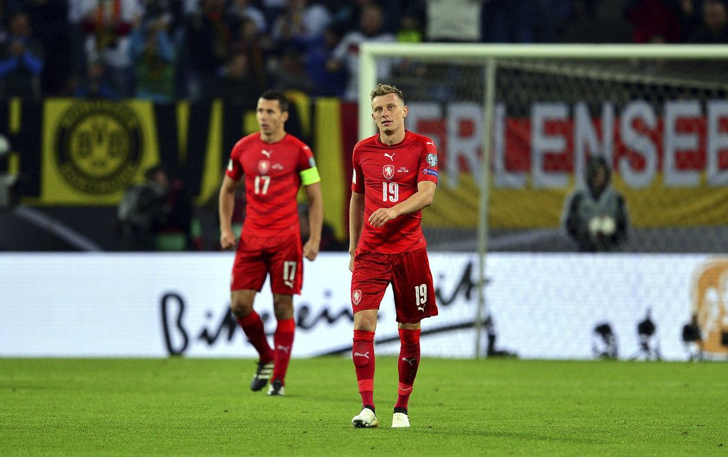 Čeští fotbalisté Marek Suchý a Ladislav Krejčí zklamaně kráčí po trávník stadionu v Hamburku. V kvalifikaci prohráli s Německem 0:3.