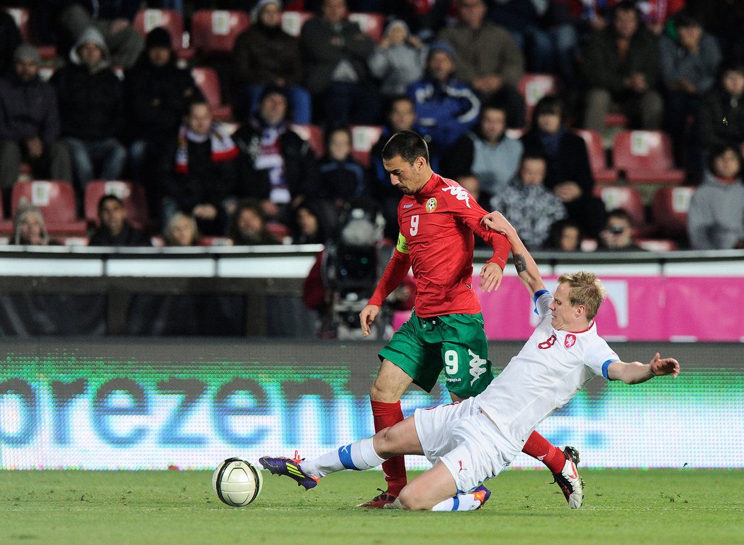 Český fotbalista David Limberský odehrává míč ve skluzu před jedním z fotbalistů Bulharska. Zápas kvalifikace o postup na MS 2014 mezi Českem a Bulharskem skončil na Letné 0:0