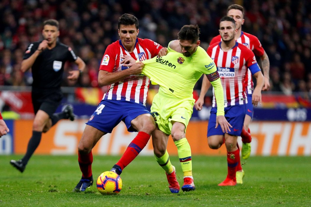 Rodri z Atlétika Madrid se s vypětím všech sil snaží zastavit Lionela Messiho