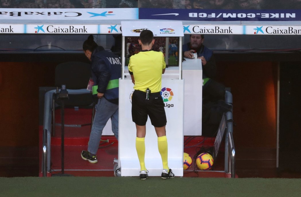 Rozhodčí Jose Sanchez kontroluje na videu zákrok Varaneho na Suáreze. Následně nařídil pokutový kop pro Barcelonu