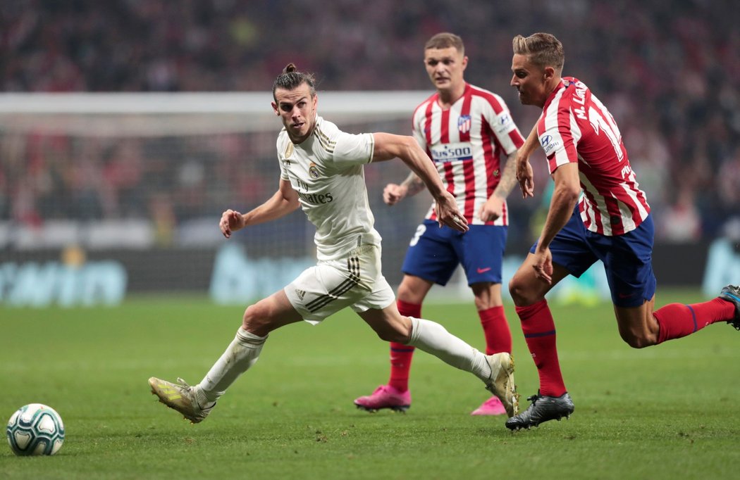 Gareth Bale uniká s míčem Marcosi Llorentemu během bezbrankového madridského derby