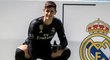 Thibaut Courtois pózuje pro média vedle znaku Realu Madrid