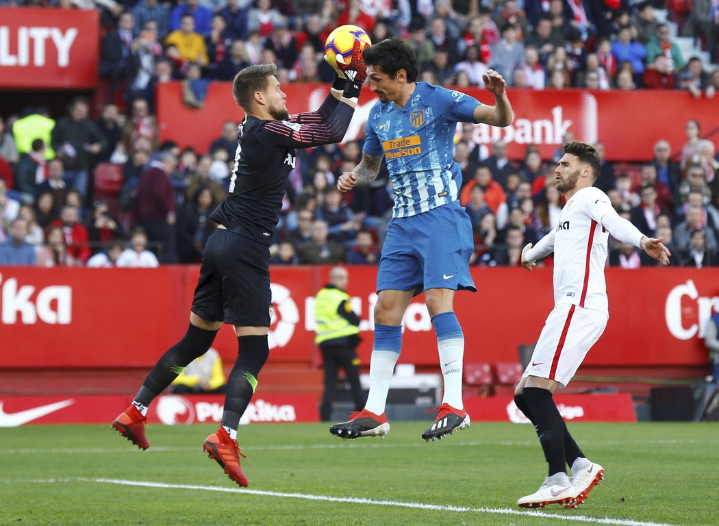 Tomáš Vaclík chytil míč před Stefanem Savicem z Atlética Madrid