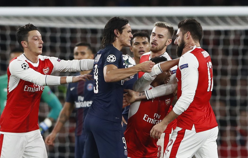 Útočník PSG Edinson Cavani v obležení hráčů Arsenalu poté, co sudí nařídil penaltu ve prospěch londýnského klubu