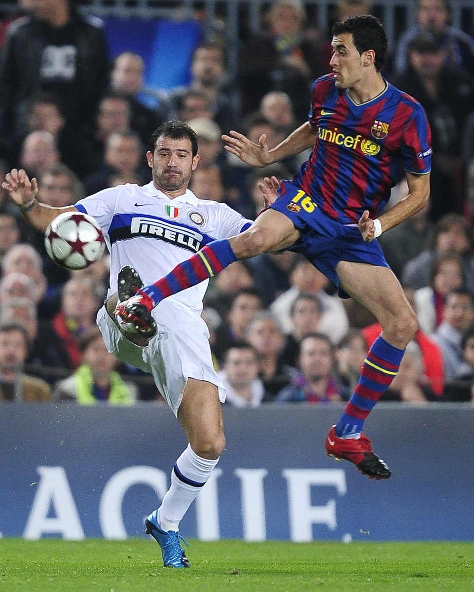 Sergio Busquets z Barcelony (vpravo) v akrobatické pozici při souboji s Dejanem Stankovičem z Interu Milán.