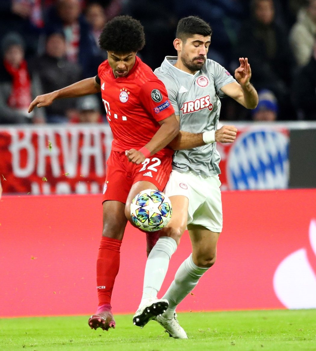 Serge Gnabry z Bayernu v souboji o míč s Andreasem Bouchalakisem z Olympiakosu