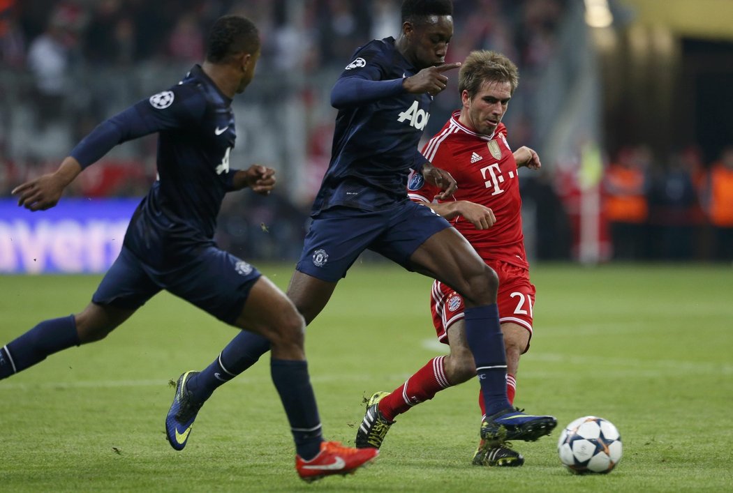 Kapitán Bayernu Philipp Lahm v souboji s obránci Manchesteru United