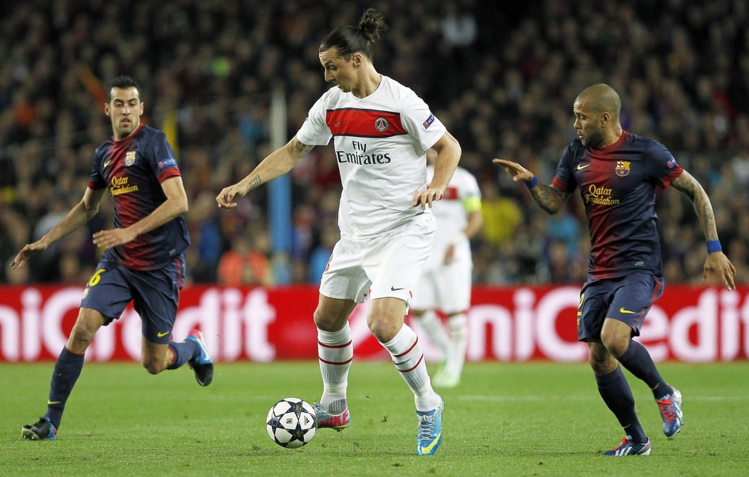Útočník Paris St. Germain Zlatan Ibrahimovic mezi barcelonskými Dani Alvesem (vpravo) a Sergio Busquetsem