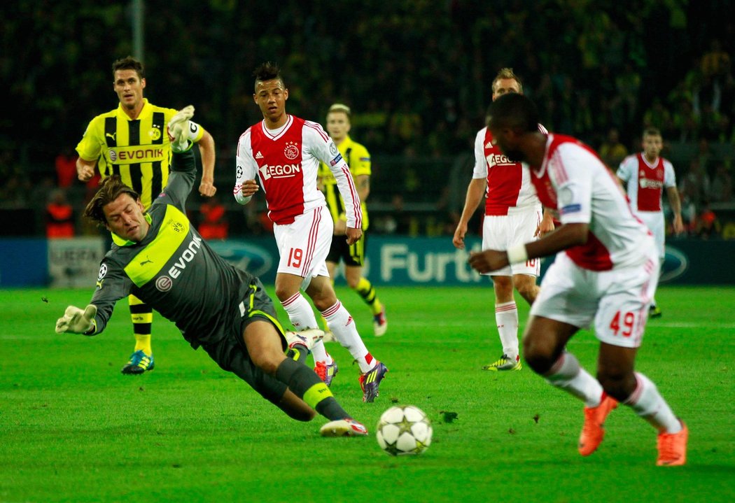 Gólman Borussie Dortmund Roman Weidenfeller se snaží zasáhnout proti šanci Ryana Babela z Ajaxu v zápase Ligy mistrů