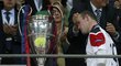Wayne Rooney prochází kolem poháru pro vítěze Ligy mistrů, který ovšem patří Barceloně
