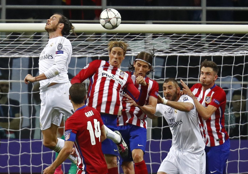 Gareth Bale se snaží hlavičkovat před brankou Atlétika, odvrátit nebezpečí chtějí Fernando Torres a Filipe Luis
