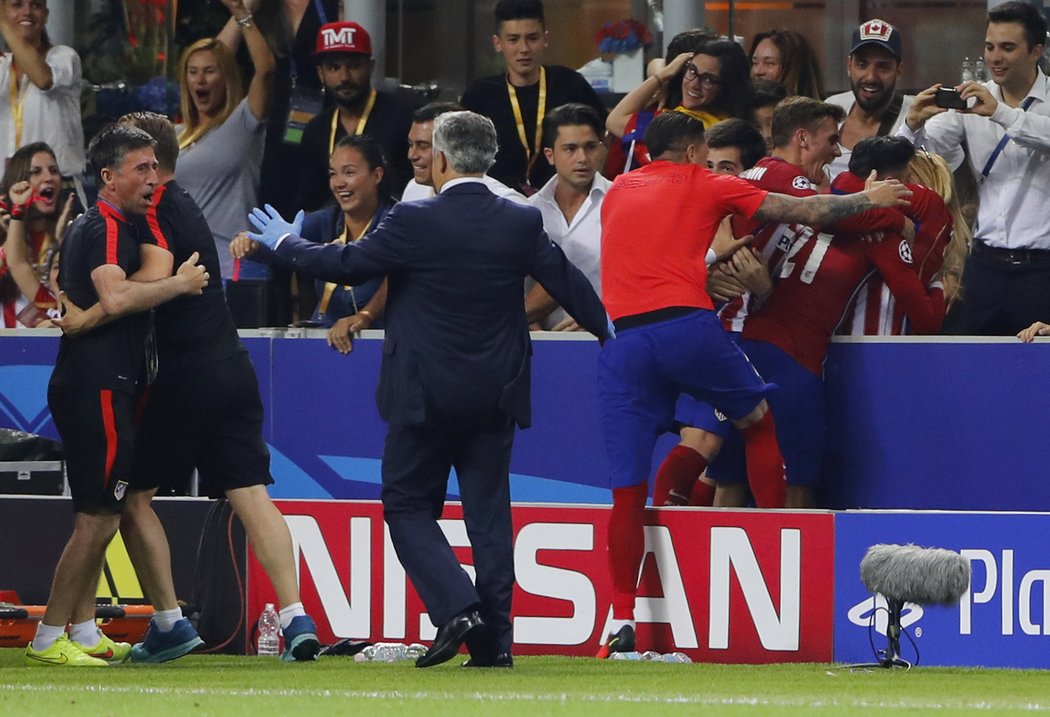 Yannick Carrasco objímá svoji přítelkyni v hledišti poté, co srovnal ve finále Ligy mistrů proti Realu Madrid. Ke šťastnému střelci se sápe Antoine Griezmann, který před tím neproměnil penaltu.