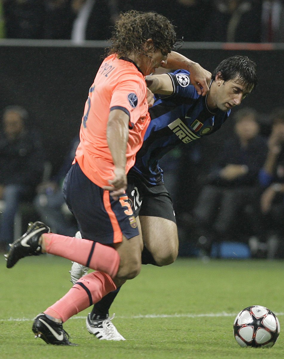 Obránce Barcelony Carlos Puyol v souboji s Diegem Militem z Interu Milán