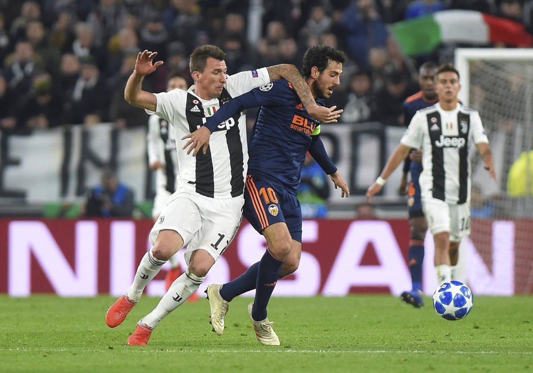 Dani Parejo tělem odstavuje útočníka Juventusu Maria Mandžukiče