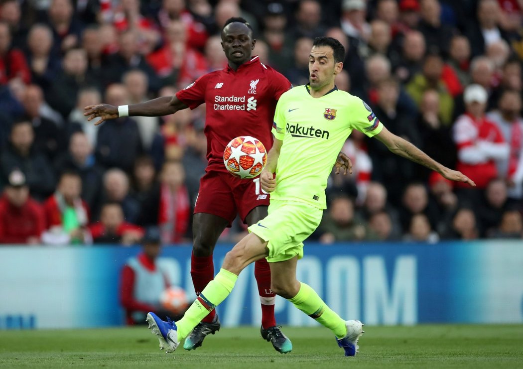 Barcelonský Sergio Busquets se snaží dostat k míči dříve než Sadio Mané z Liverpoolu