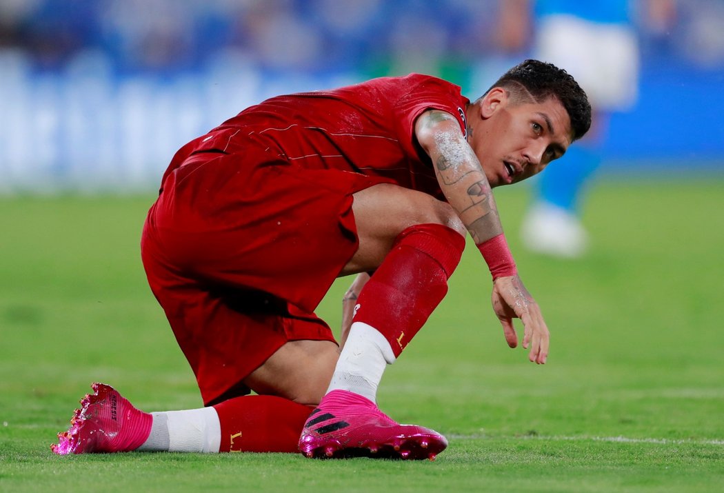 Liverpoolský Roberto Firmino se sbírá ze země po faulu na svou osobu v zápase s Neapolí