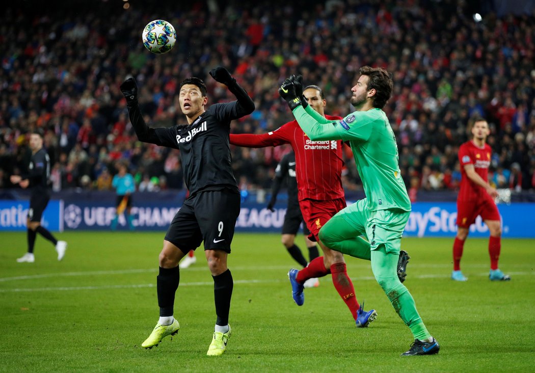 Gólman Liverpoolu Alisson jde do vzdušného souboje s Hwang Hee-chanem ze Salcburku