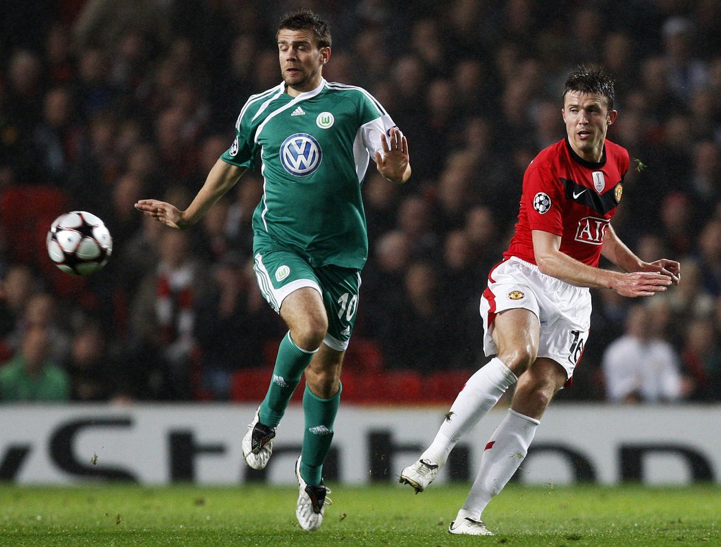 Michael Carrick z Manchesteru United (vpravo) posílá míč kolem Zvezdana Misimoviče z Wolfsburgu.
