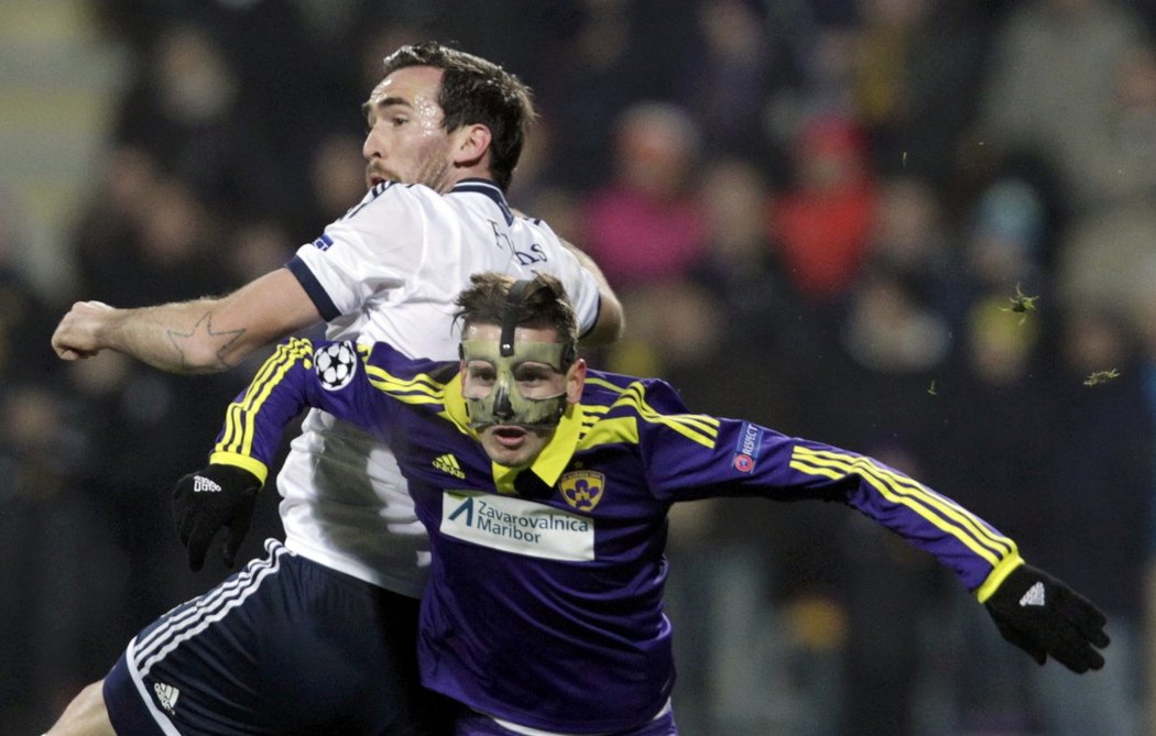 Petar Stojanovic z Mariboru s maskou na zlomeném nose se snaží ubránit Christiana Fuchse ze Schalke