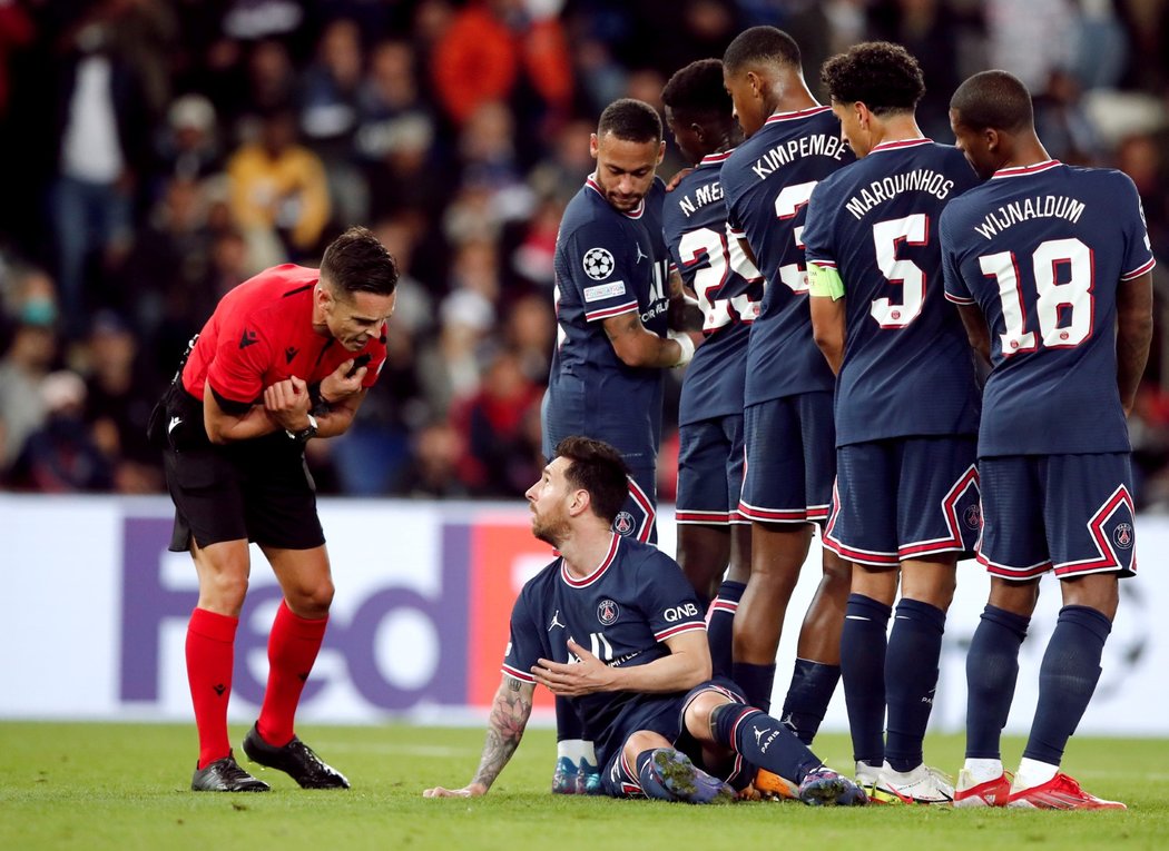 Lionel Messi se baví s rozhodčím, když ucpává díru pod zdí PSG v závěru zápasu se Citizens