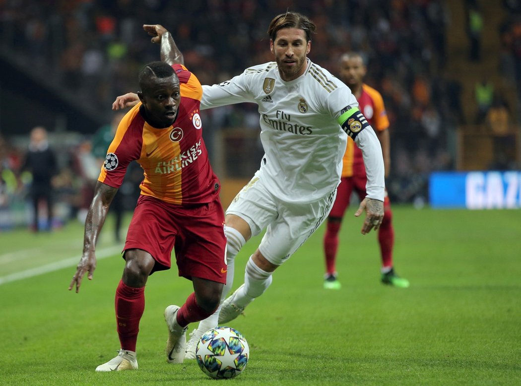 Kapitán Realu Madrid Sergio Ramos se snaží zastavit pronikajícího Jeana Michaela Seriho z Galatasaraye