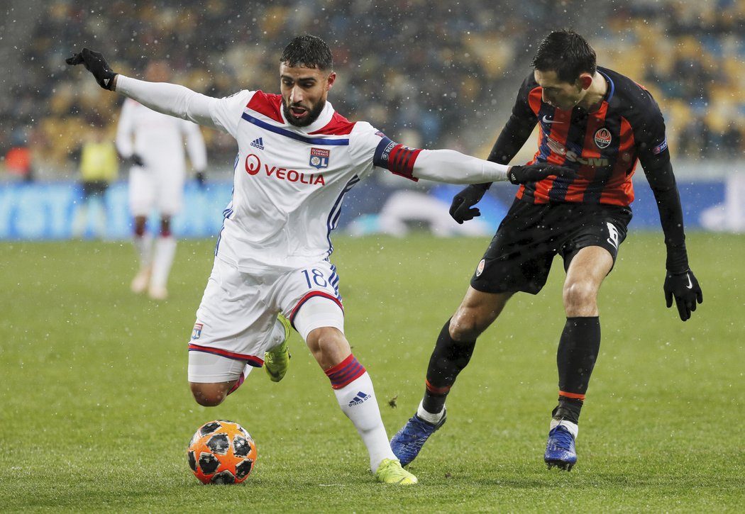 Kapitán Lyonu Nabil Fekir si kryje míč před dotírajícím hráčem Šachtaru Tarasem Stěpaněnkem