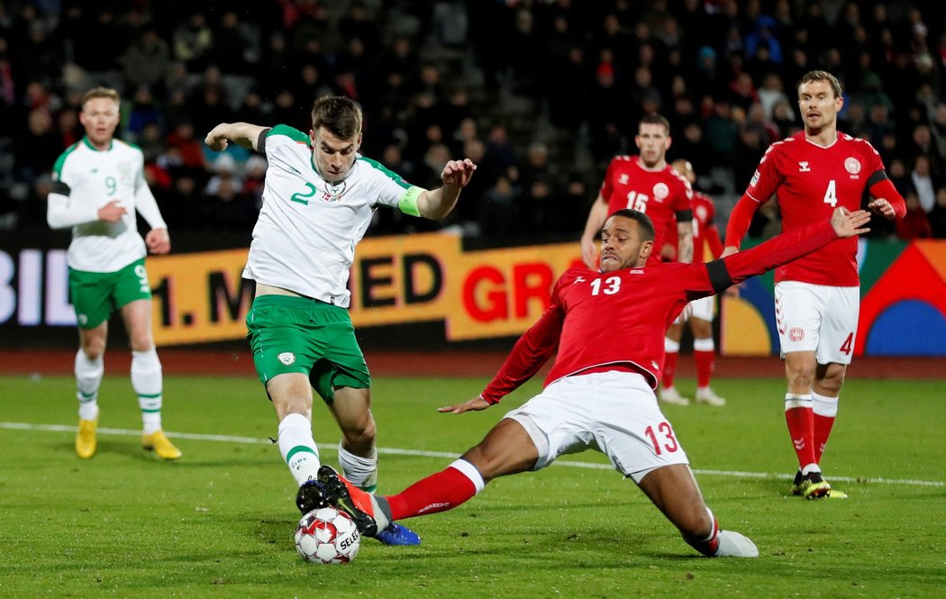 Dán Mathias Jorgensen se skluzem snaží zastavit irského fotbalistu Seamuse Colemana