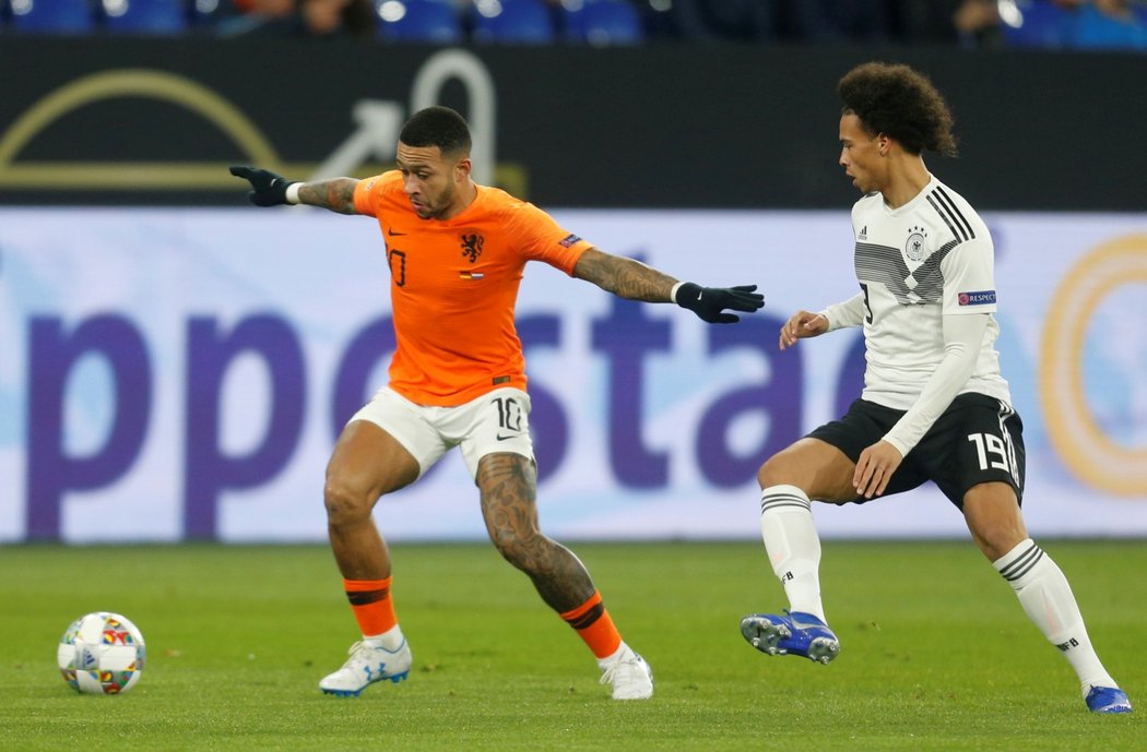 Nizozemský fotbalista Memphis Depay si kryje míč před dotírajícím Němcem Leroyem Saném