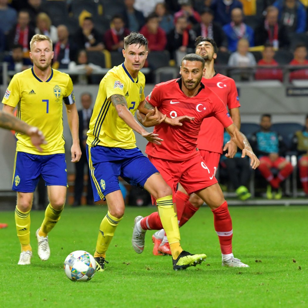 Mikael Lustig (uprostřed v popředí) bojuje o míč s Cenkem Tosunem (napravo v popředí) během souboje Ligy národů B skupiny 2