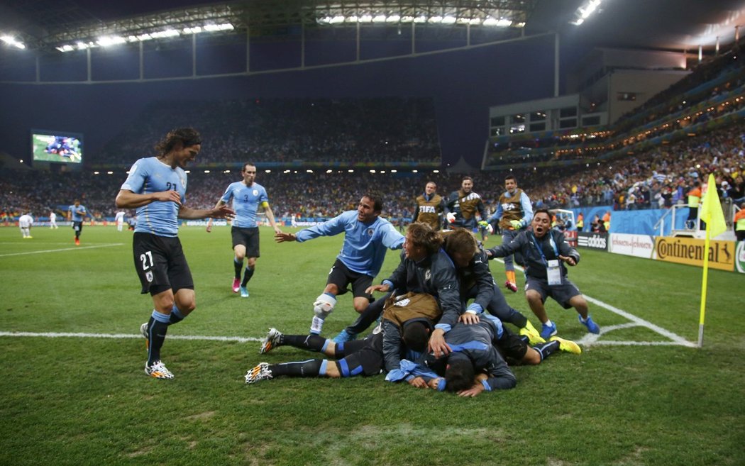 Uruguayští fotbalisté se vrhají na střelce rozhodujícího gólu Suáreze