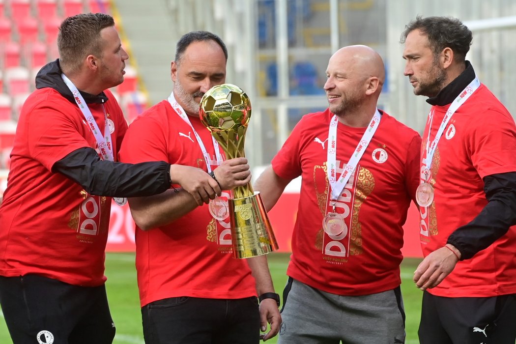 Trenér Slavie Jindřich Trpišovský se svými kolegy z realizačního týmu a trofejí pro vítěze Mol Cupu 2020/2021