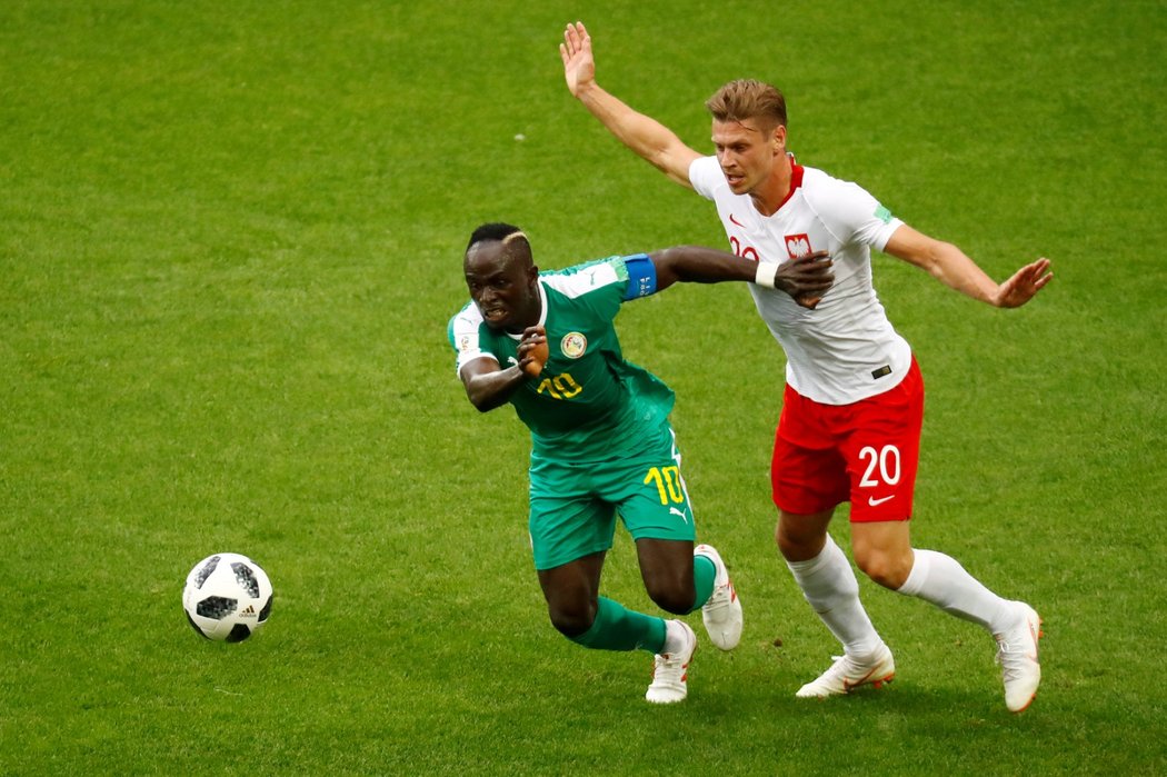 Sadio Mané bráněný polským obráncem Lukaszem Piszczekem