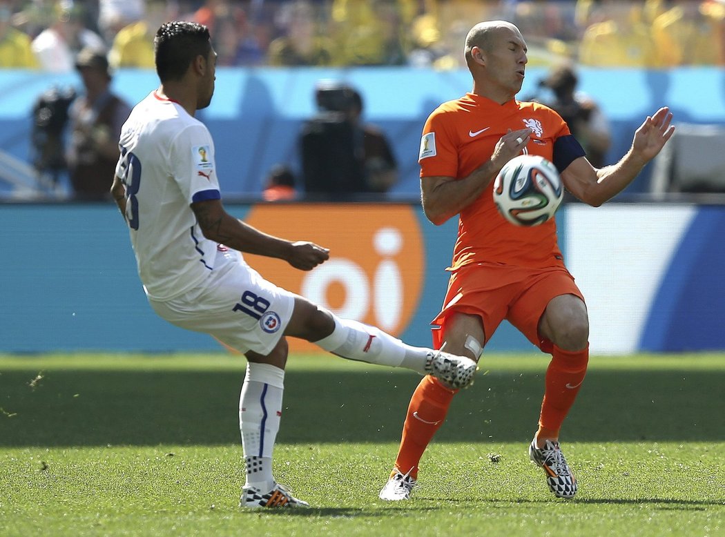 Chilský Gonzalo Jara odkopává míč před Arjenem Robbenem.