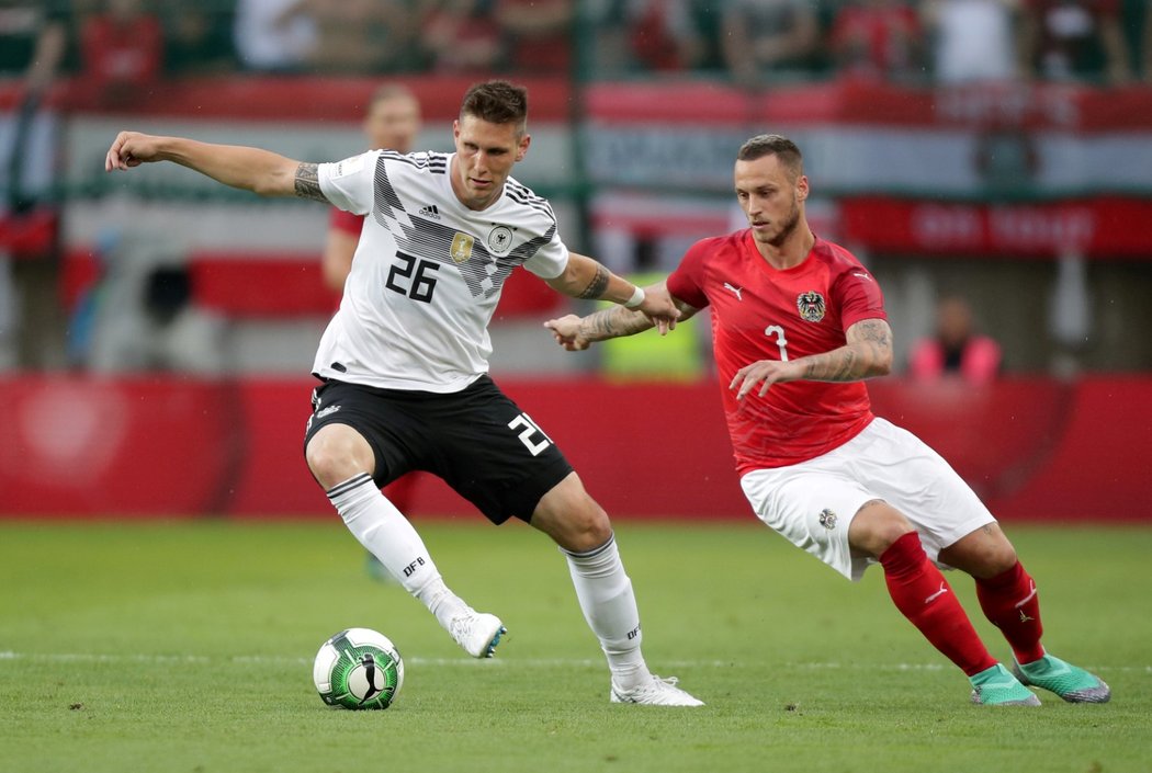Rakouský útočník Marko Arnautovic se snaží získat míč v souboji s Niklasem Sülem z Německa