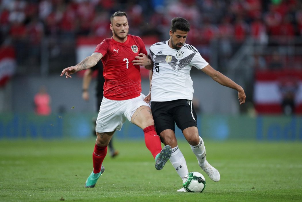 Německý záložník Sami Khedira se snaží pokrýt míč před dotírajícím Markem Arnautovicem z Rakouska