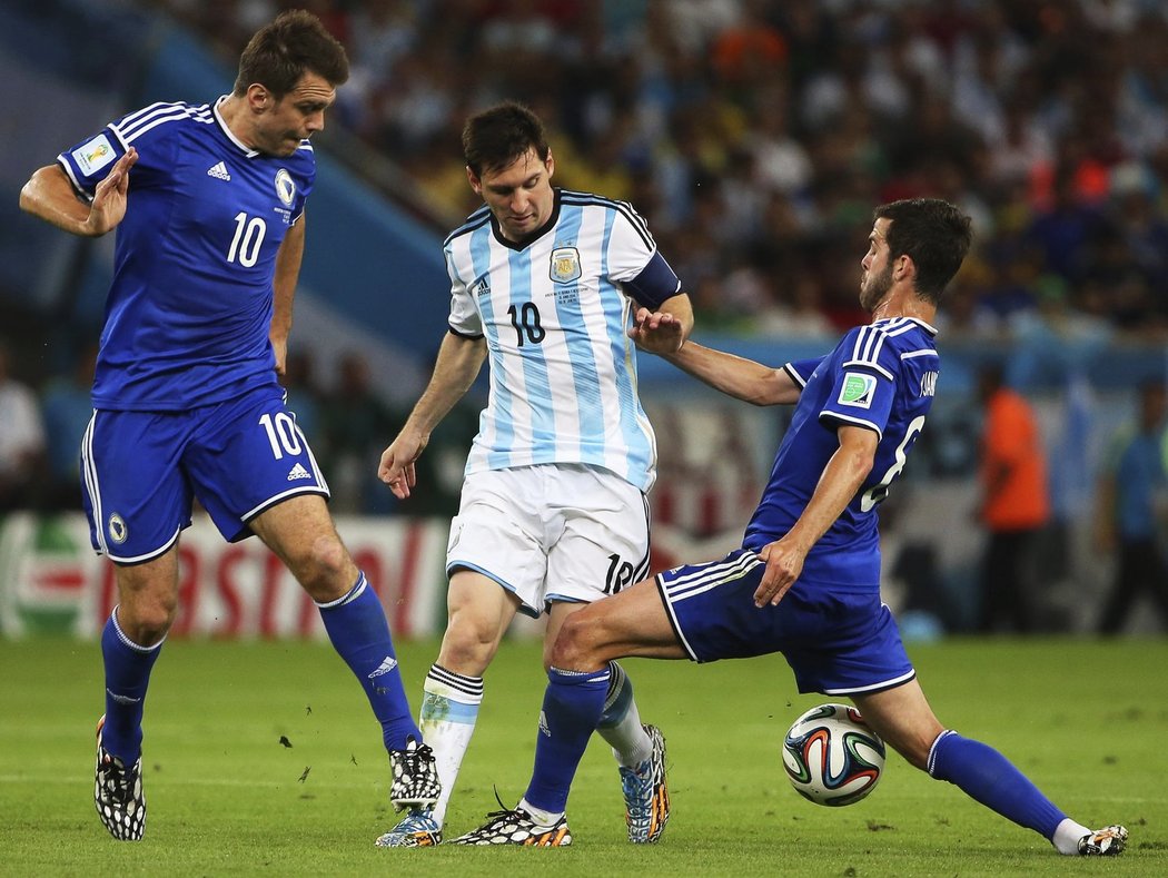 Lionel Messi se snaží projít přes dvojici bosenských obránců