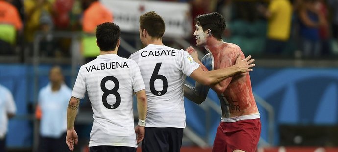 Francouzští záložníci Valbuena a Cabaye po zápase se Švýcarskem přijímají gratulace od fanouška přímo na trávníku