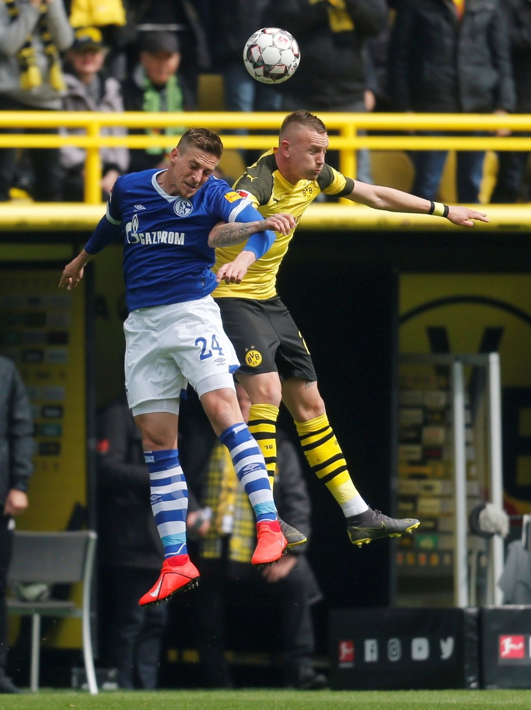 Útočník Dortmundu Marius Wolf v hlavičkovém souboji s obráncem Schalke Bastianem Oczipkou