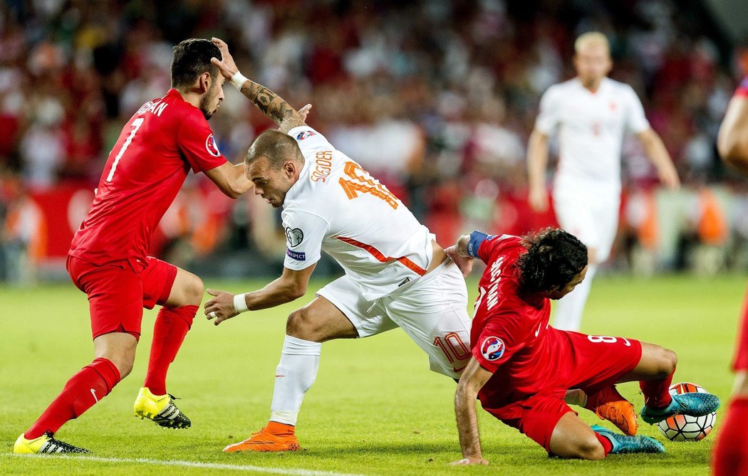 Nizozemský fotbalista Wesley Sneijder bojuje s dvojicí tureckých soupeřů v utkání kvalifikace o postup na EURO 2016. Turci v půli vedli 2:0.