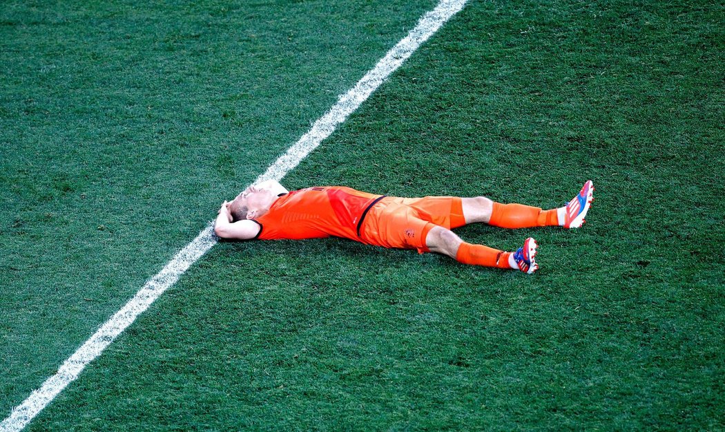 Arjen Robben leží zklamaně na trávníku po prohře 1:2 s Německem