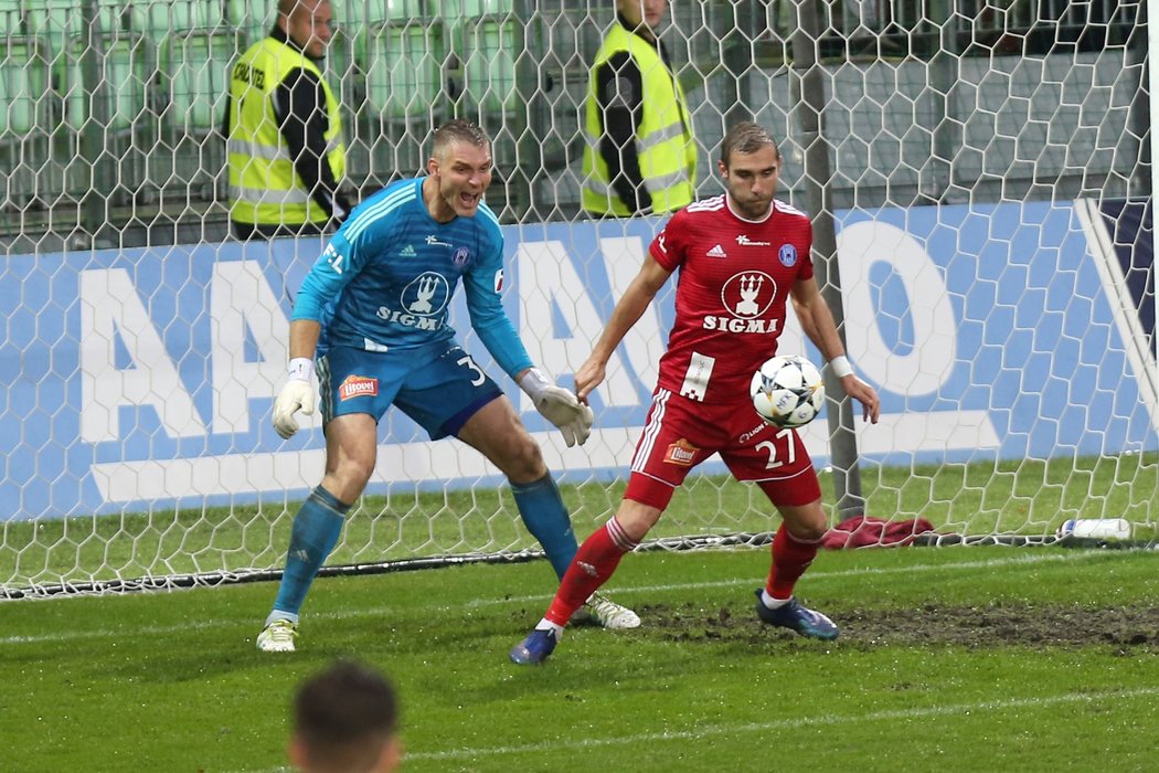 Olomoucký Martin Sladký zastavuje v malém vápně míč mířící na branku gólmana Miloše Buchty, který konání svého spoluhráče přihlíží v pozadí