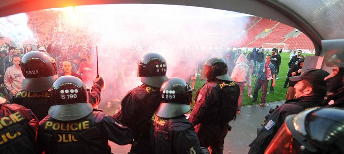 Policejní těžkooděnci se snaží zabránit slávistickým rowdies ve vniknutí do útrob stadionu