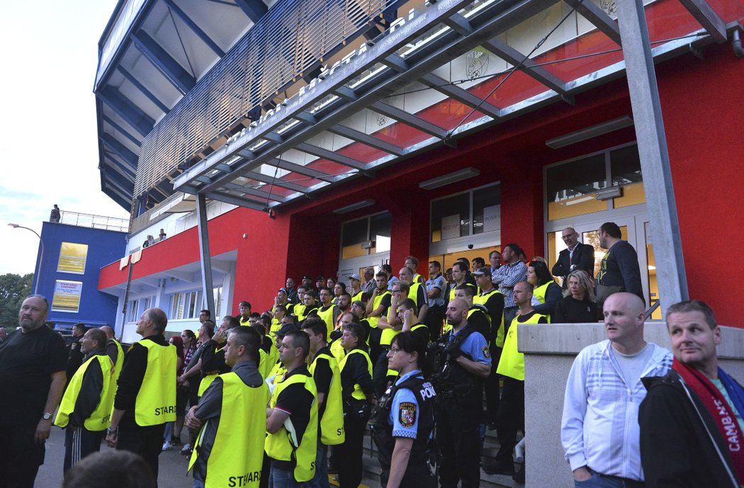  Pořadatelé sledují odchod fanoušků ze stadionu