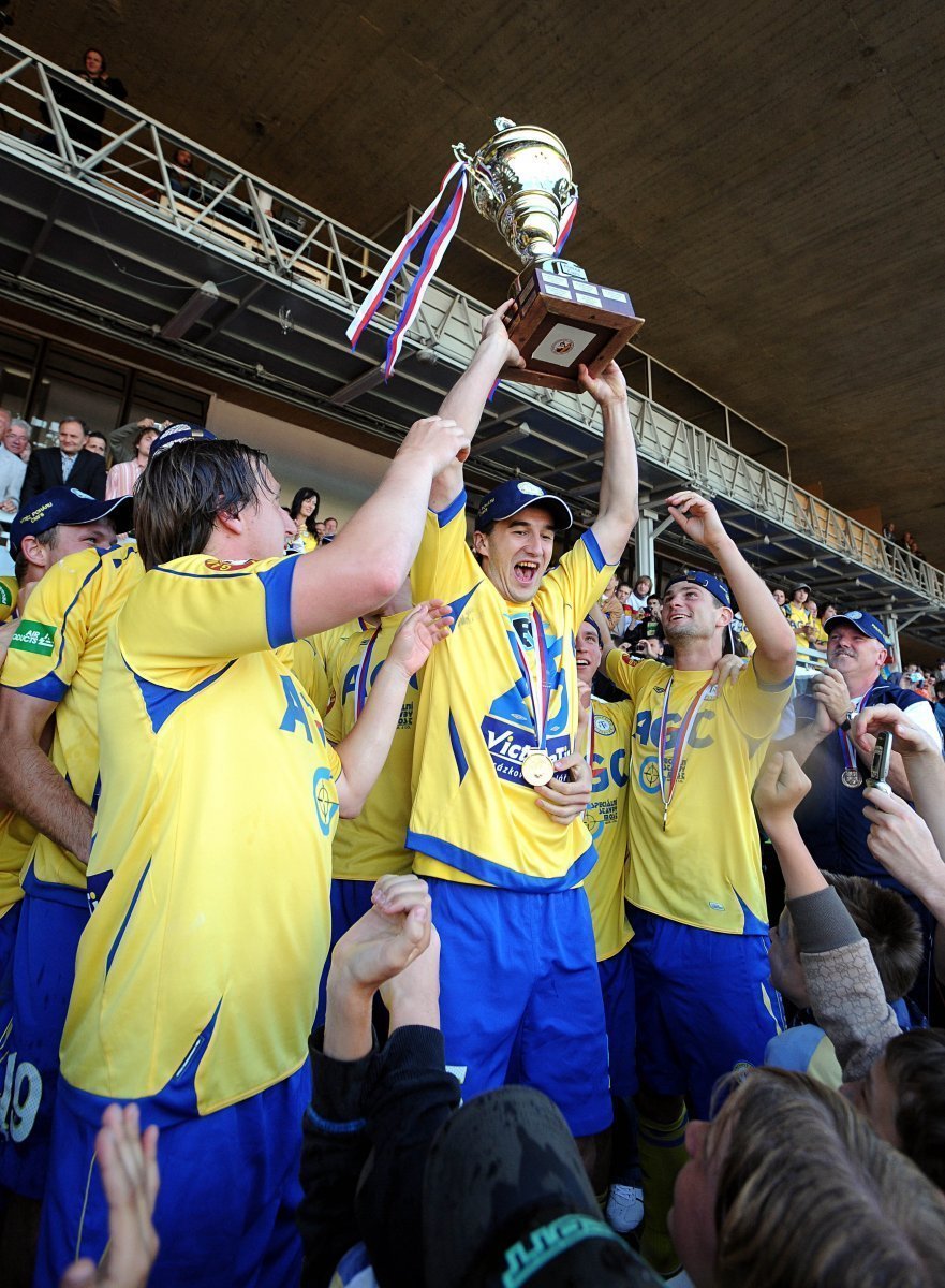 Hrdina utkání Aidin Mahmutovič drží pohár nad hlavou