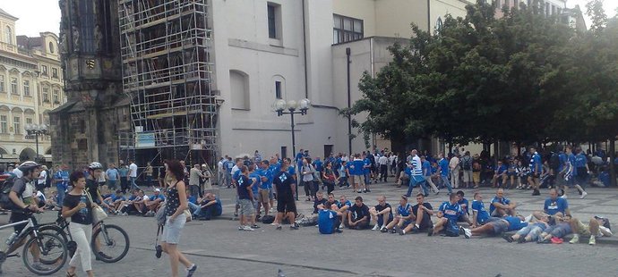 Fanoušci fotbalového týmu Lech Poznaň posedávají na Staroměstském náměstí v centru Prahy